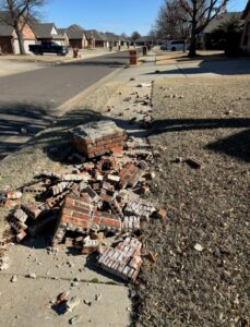 Damaged brick mailbox before rebuild with scattered bricks and debris